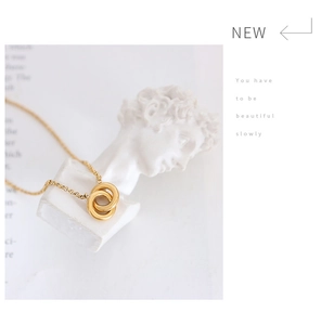 Detail of interlocking double gold rings on a stylish white marble artistic display