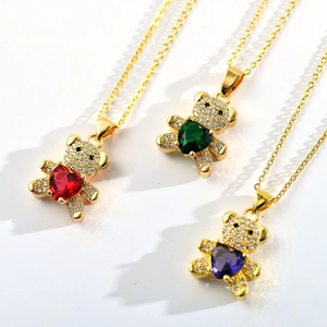 Detailed close-up of gold bear pendants with colorful heart-shaped cubic zirconia stones