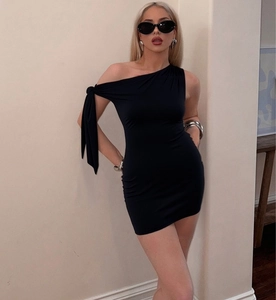 Détail d'une mini-robe noire à une épaule avec nœud et tissu extensible moulant élégant