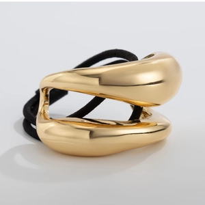 Close-up of golden geometric hollow metal charm on elastic hair tie for women