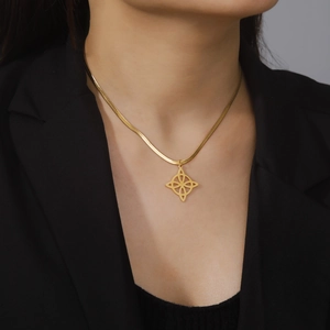 Gold Celtic knot necklace with hollow clover pendant on snake chain worn by a model