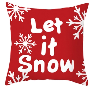 Close-up of red Christmas pillow case with Let it Snow text and white snowflakes