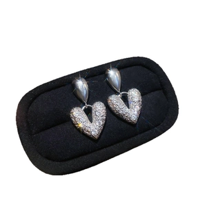 Minimalist silver needle heart earrings with zircon studs in a black velvet jewelry box