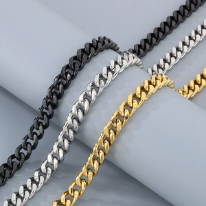 Detailed view of three polished cuban link chains in black, silver, and gold finishes