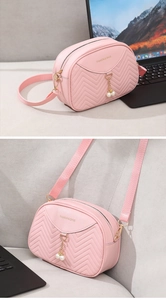 Pink crossbody bag with V-shaped quilting and elegant pearl pendant detail on the front