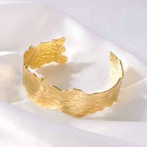 Retro 18K gold plated stainless steel open bangle with unique leaf texture on white silk