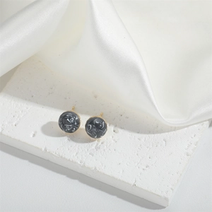 French vintage round marble pattern stud earrings with gold pins on white silk background