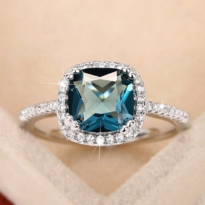 Vintage cushion-cut royal blue gemstone ring with halo diamonds on silver band