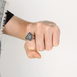 Macro shot of retro silver ring featuring evil eye design worn on model hand