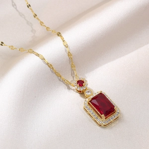 Golden necklace featuring a rectangular red gemstone pendant on elegant light silk fabric