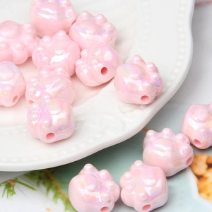 Macro detail of iridescent pink cat paw acrylic beads for DIY jewelry and crafts