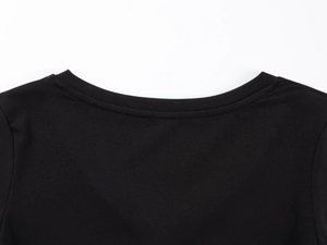 Détail des coutures du col en V et de la texture du tissu modal sur un haut noir ajusté