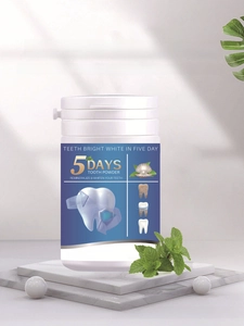 Dettaglio di polvere sbiancante per denti su marmo con foglie di menta fresca