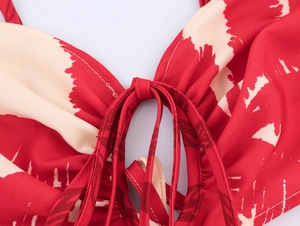 Detail of red beach dress with coconut tree print, front tie design and thin straps