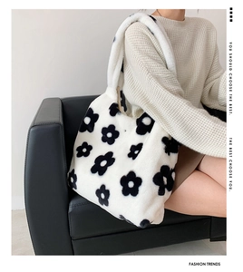 Detail of plush tote bag with black and white flower pattern on a soft woolly texture