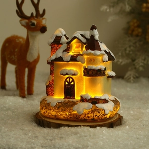 Gros plan d'une maison de Noël en résine lumineuse avec lumière chaude et neige