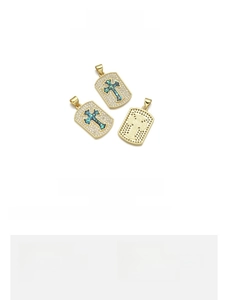 Macro view of 18K gold plated copper cross pendant with green opal inlay and zircon detail