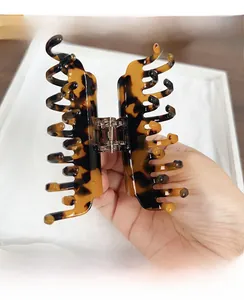 Detail of tortoise shell acetate hair claw clip with double-row teeth and metal spring
