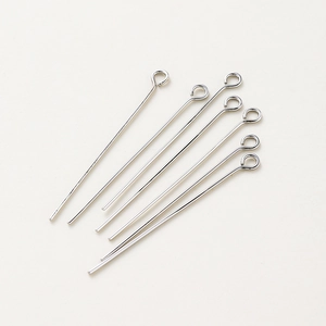 Silver-plated metal eye pins for DIY jewelry making arranged in a sunburst pattern