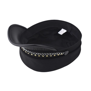 Detail of black military cap with silver chain, gold star charms and faux leather brim
