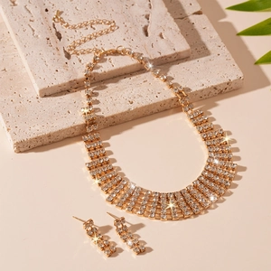 Detailed view of luxury gold fringe necklace and earrings set with crystal rhinestones