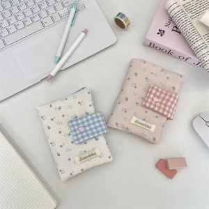 Detail of floral fabric book covers with heart buttons and delicate brand label