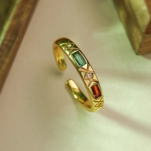 Detailed macro view of 18K gold-plated ring with emerald-cut gems and star engravings