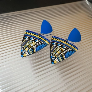 Detail of tribal pattern painted triangle earrings in blue and yellow geometric style