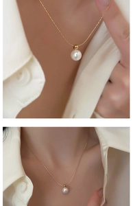 Detailed close-up of a minimalist gold pearl necklace on a model's collarbone