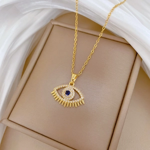 Detail of evil eye pendant with blue crystal and white diamonds on gold chain