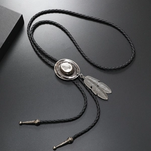 Detail of vintage cowboy hat bolo tie with silver feathers and black braided leather cord