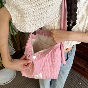 Detail of pink pleated canvas bag showing internal space and magnetic snap closure