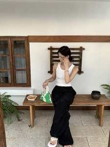 Outdoor lifestyle shot of a model holding a green and white checkered crochet tote bag
