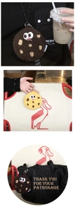Porte-monnaie en peluche biscuit avec expression rigolote accroché aux sacs