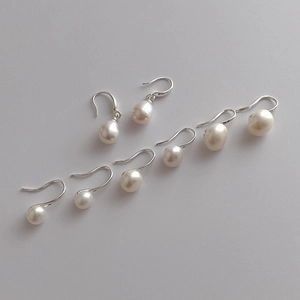 Detailed close-up of natural freshwater pearl earrings with elegant silver hooks