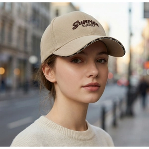 Detail of beige cotton baseball cap featuring Sunrise SUNSET embroidery and SPORT brim print