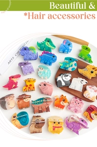Detailed view of colorful acrylic animal hair clips set on a wooden tray with books
