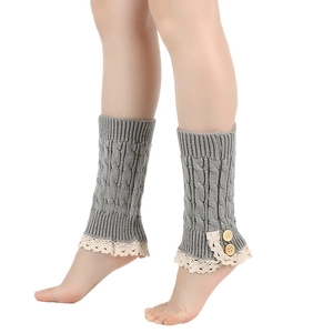 Detail of gray knitted leg warmers featuring elegant lace trim and wooden button accents
