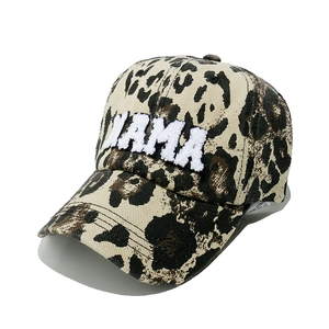 Detail of white MAMA towel embroidery on a leopard print washed baseball cap