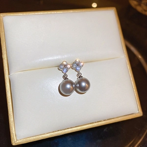 Elegant silver earrings featuring a clover zircon top and a grey pearl in a jewelry box