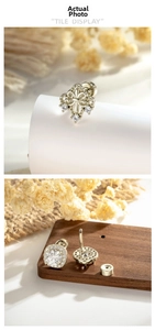 Close-up of vintage gold earrings with zirconia inlay and detailed fleur-de-lis engravings