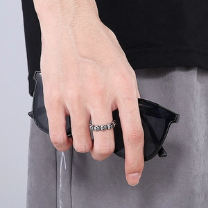 Detail of gothic skull ring in oxidized steel worn for a punk rock street fashion look