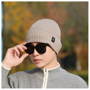 Close-up of beige ribbed knit beanie featuring a classic side brand woven label detail