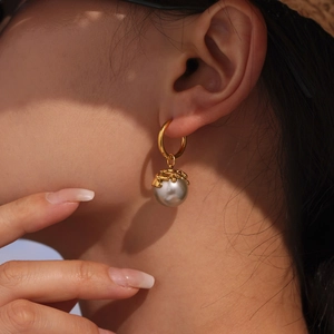 Minimalist 18K gold earrings with grey pearl drop and petal detail on female model