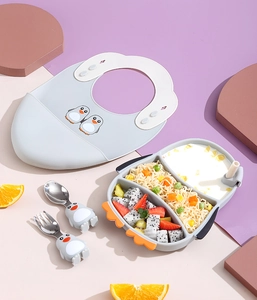 Close-up of penguin silicone feeding set with bib, suction plate, spoon and fork