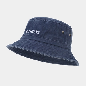 Détail de la broderie Brooklyn sur un bob en coton bleu marine avec œillets métalliques