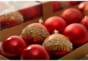 Close-up of red and gold Christmas balls with glitter and beads in a brown box