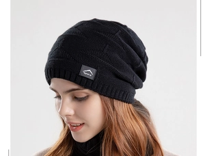 Détail d'un bonnet en maille noire avec écusson de sport et motif en losange