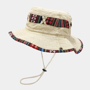 Close-up of beige outdoor sun hat featuring ethnic pattern ribbons and adjustable chin strap