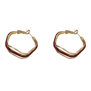 Irregular wavy red enamel hoop earrings in gold metal finish with silver needles